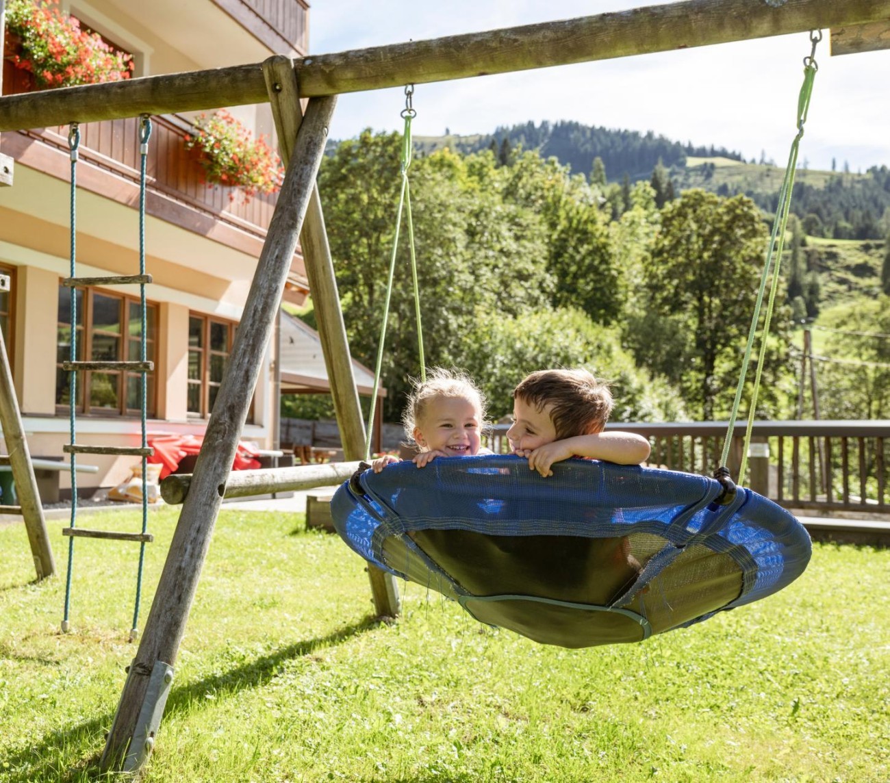 Kinder spielen auf einem Spielplatz inmitten einer Berglandschaft. &copy;Shutterstock