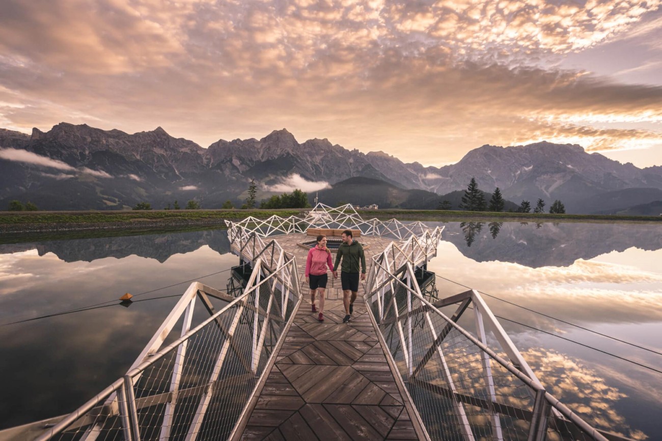 Ein Paar spaziert bei Sonnenuntergang am Prinzensee vor beeindruckender Bergkulisse Hochk&ouml;nigs. &copy;TVB_Hochk&ouml;nig