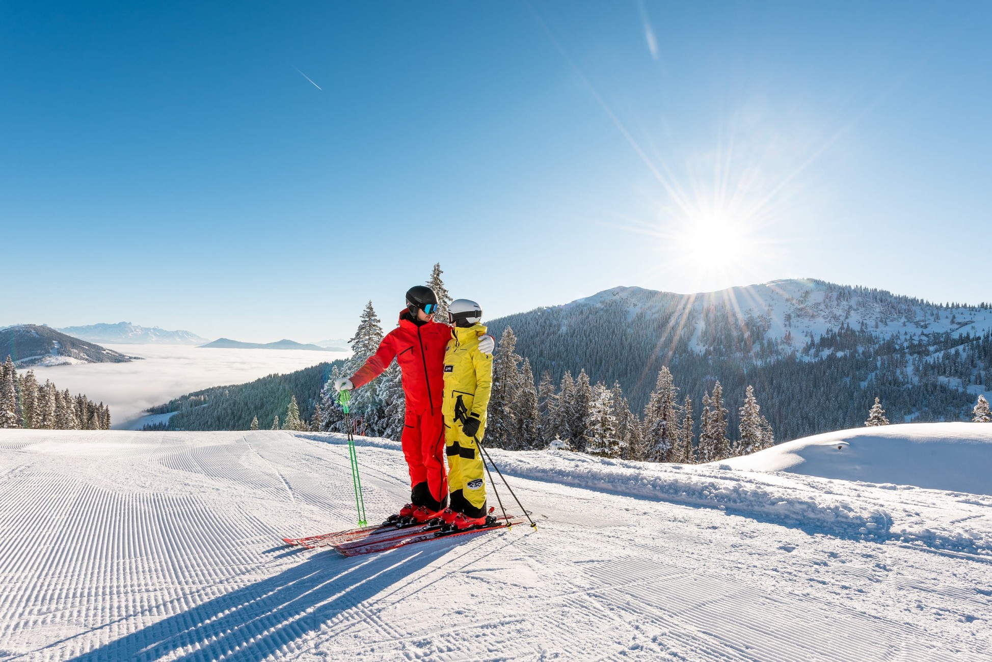 Skifahrer genie&szlig;en die Sonne auf der Piste im Winterurlaub. &copy;TVB_Hochk&ouml;nig