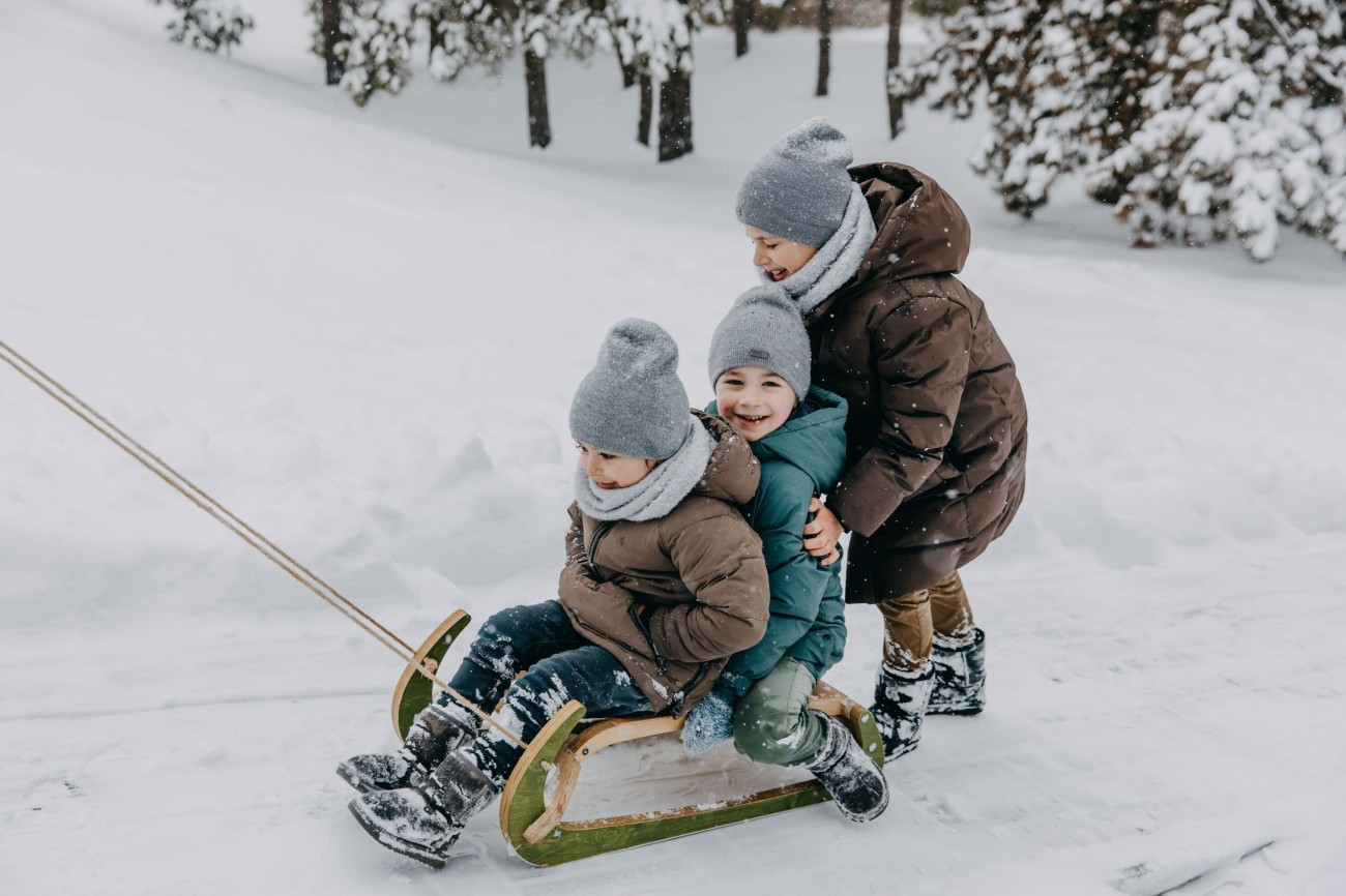 Kinder rodeln fr&ouml;hlich im Schnee im Winterurlaub mit der Familie im Hotel Bachschmied. &copy;Shutterstock