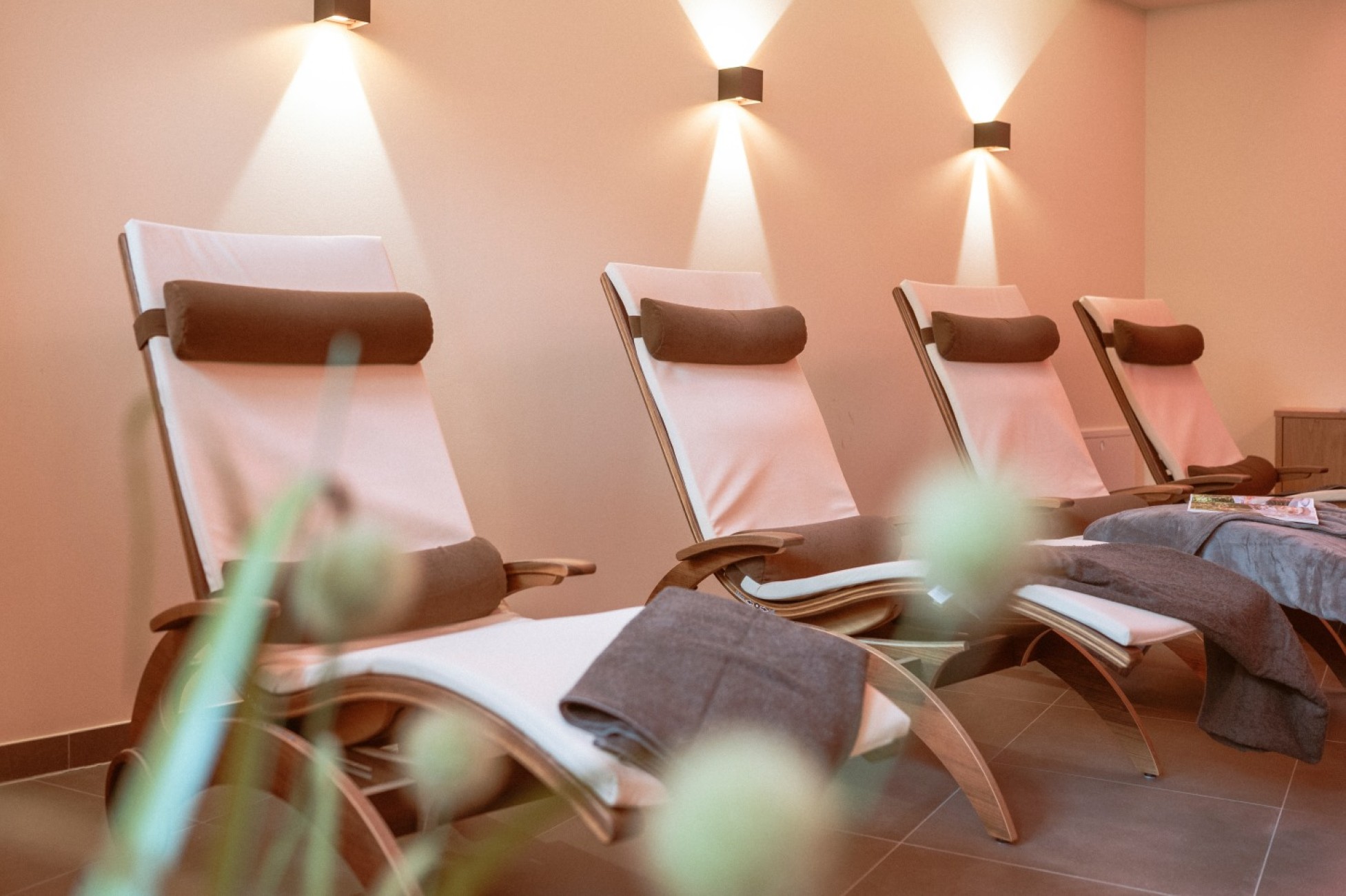 Vier bequeme Liegest&uuml;hle im entspannten Spa-Raum mit sanfter Beleuchtung des Hotel Bachschmied