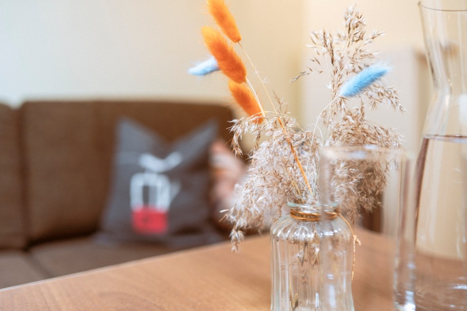 Vase mit getrockneten Blumen auf einem Holztisch im Hotel Bachschmied.