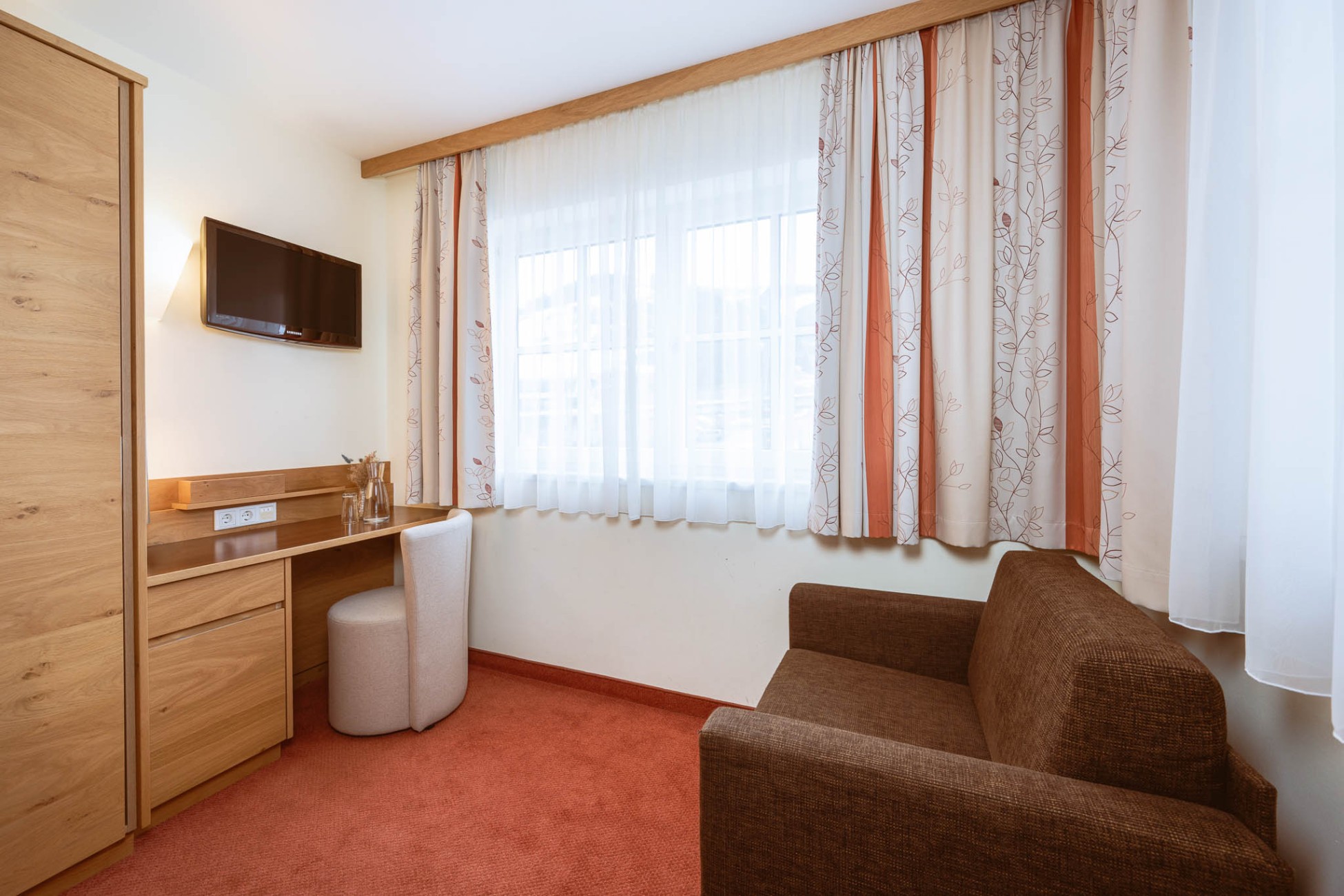 Wohnbereich mit Fernseher im Doppelzimmer mit getrennten Schlafr&auml;umen im Hotel Bachschmied.