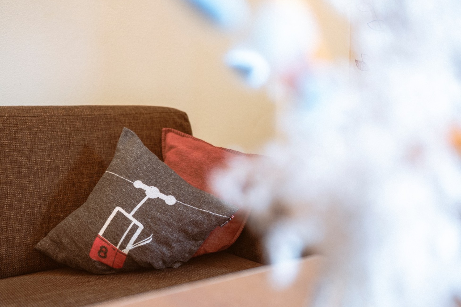 Ein braunes Sofa mit einem Kissen, das eine Seilbahn zeigt im Bachmied.