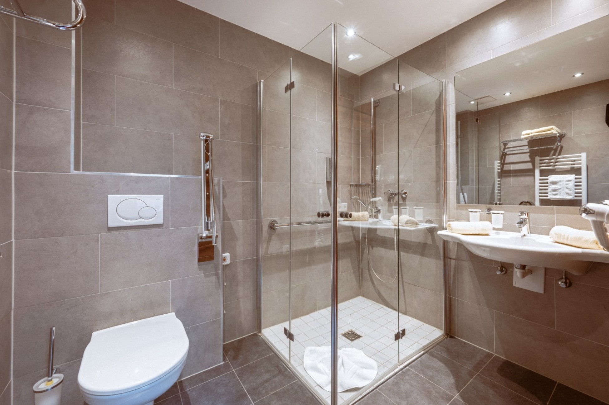 Modernes Badezimmer mit Duschkabine, WC und Waschtisch in warmer Beleuchtung im Bachschmied.