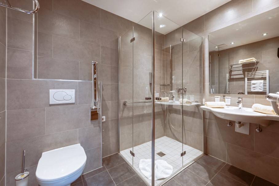 Modernes Badezimmer mit Duschkabine, WC und Waschtisch in warmer Beleuchtung im Bachschmied.