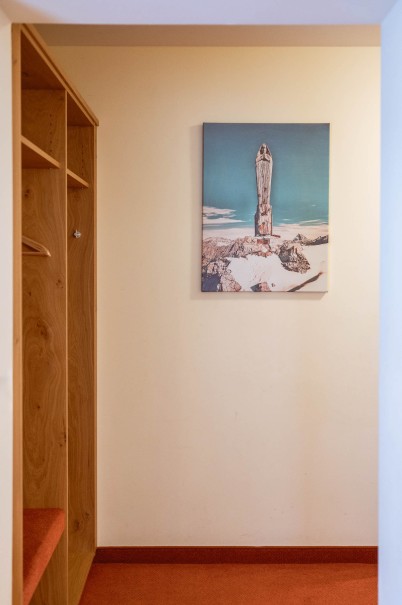 Bild an der Wand neben Holzkasten im Familienzimmer Hotel Bachschmied.